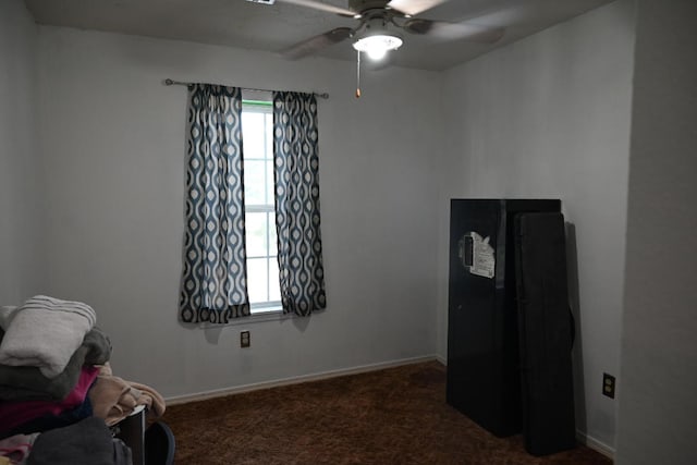 miscellaneous room featuring ceiling fan, a wealth of natural light, and dark carpet