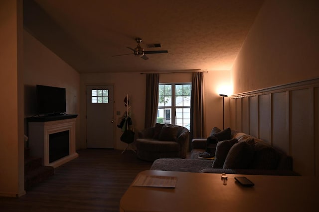 living room with ceiling fan, lofted ceiling, and hardwood / wood-style floors