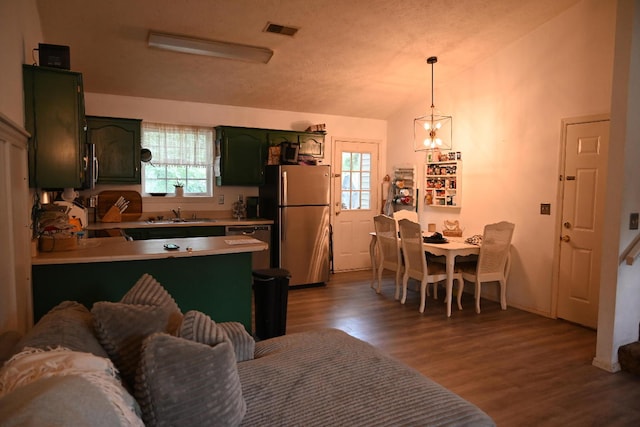 kitchen featuring a wealth of natural light, appliances with stainless steel finishes, wood-type flooring, and green cabinetry