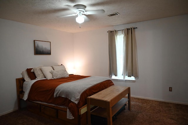 carpeted bedroom featuring ceiling fan and a textured ceiling