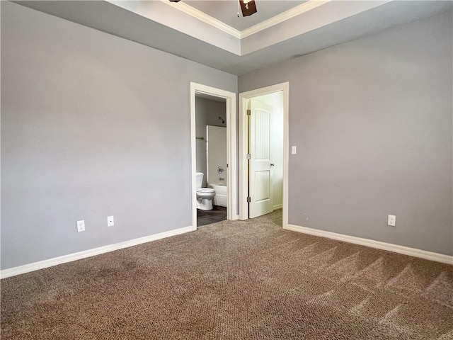 unfurnished bedroom featuring baseboards, carpet, a tray ceiling, and crown molding