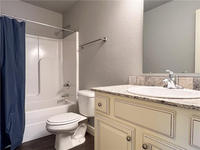 full bathroom featuring a textured wall, toilet, shower / bath combo, vanity, and wood finished floors