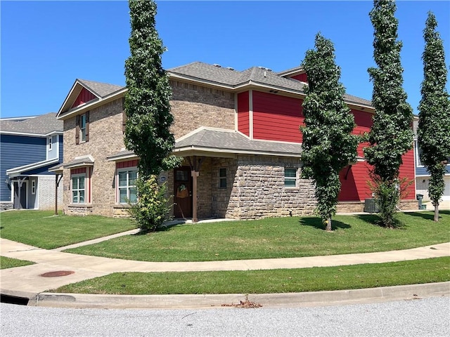 view of front of property with stone siding, a shingled roof, and a front yard