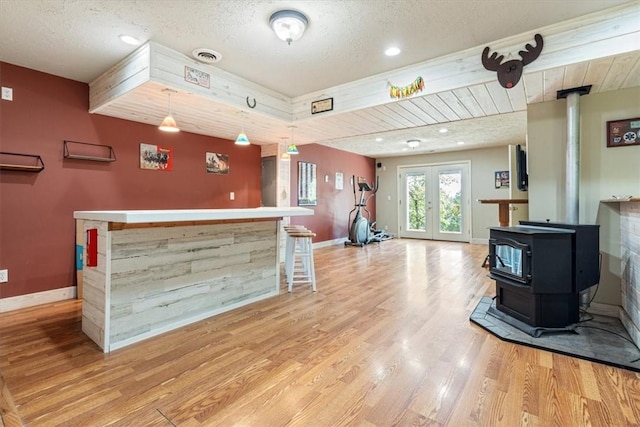 interior space with french doors, a bar, visible vents, and a wood stove