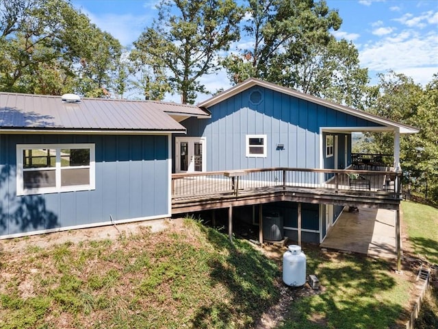 back of house with central AC unit, french doors, metal roof, a yard, and a deck