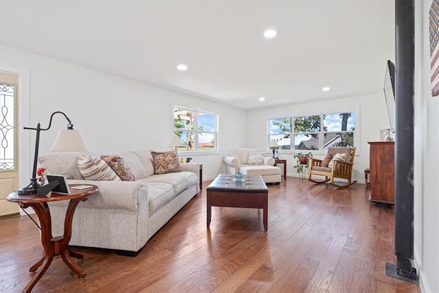 living room with recessed lighting, baseboards, and wood-type flooring