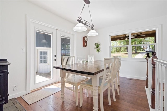 dining space with baseboards and hardwood / wood-style flooring