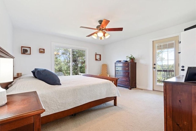 bedroom featuring light colored carpet, multiple windows, ceiling fan, and access to outside