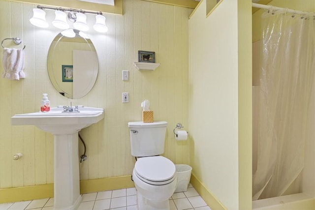 bathroom with tile patterned flooring, curtained shower, toilet, and baseboards