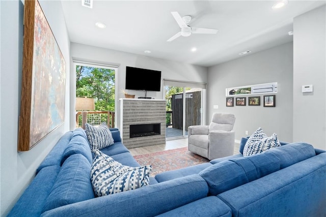 living area with recessed lighting, visible vents, a ceiling fan, a brick fireplace, and wood finished floors