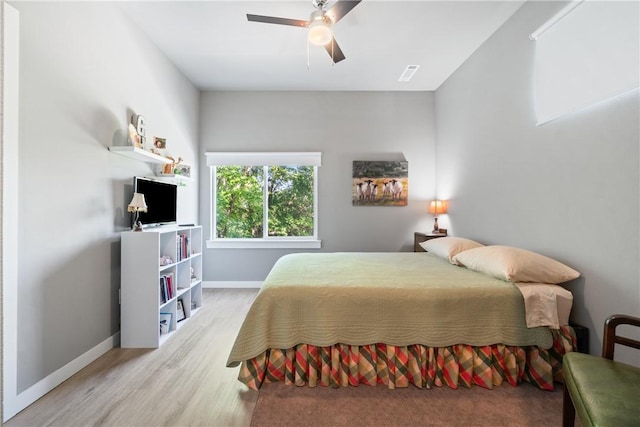 bedroom featuring light wood finished floors, a ceiling fan, visible vents, and baseboards