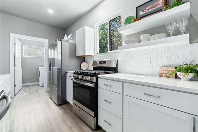 kitchen featuring open shelves, tasteful backsplash, light countertops, appliances with stainless steel finishes, and white cabinets