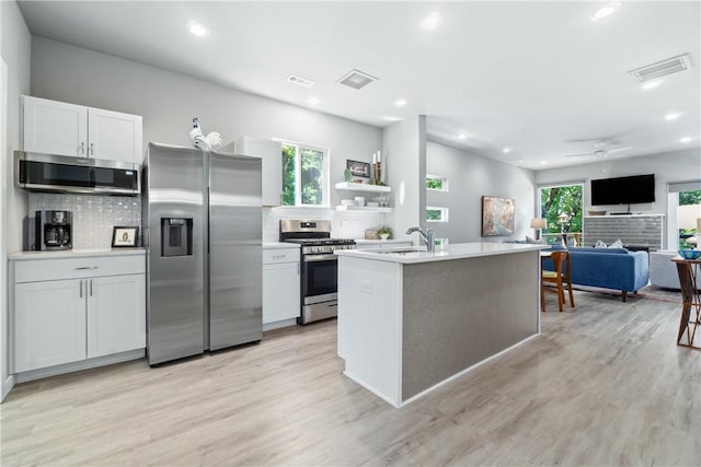 kitchen featuring stainless steel appliances, visible vents, and a sink