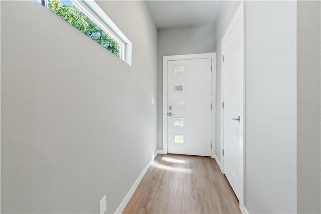 doorway with baseboards and light wood finished floors