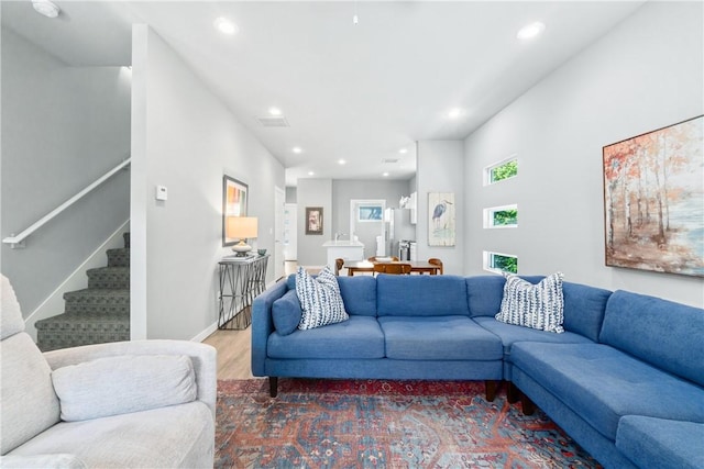 living area featuring stairs, baseboards, wood finished floors, and recessed lighting