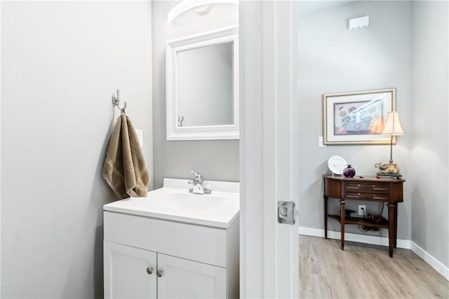 bathroom featuring wood finished floors, vanity, and baseboards