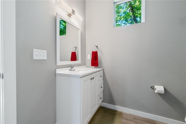 bathroom featuring vanity, baseboards, and wood finished floors