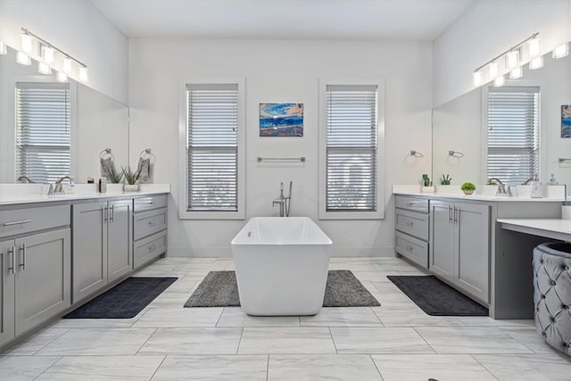 bathroom featuring a bathing tub, double vanity, and tile patterned floors