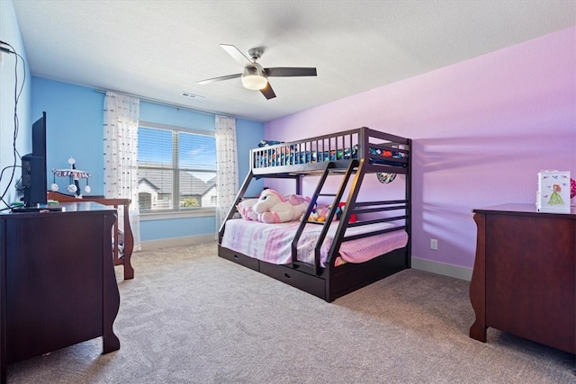 bedroom with ceiling fan, light carpet, and a textured ceiling