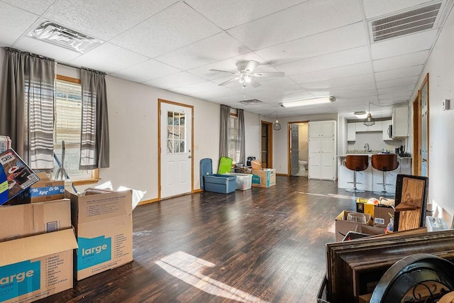 living room with dark hardwood / wood-style flooring, sink, a paneled ceiling, and ceiling fan