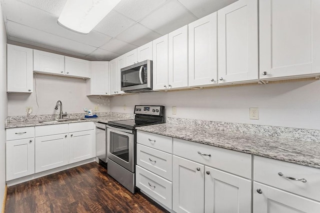 kitchen featuring dark hardwood / wood-style flooring, sink, stainless steel appliances, and white cabinets