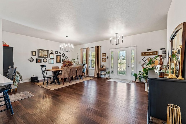 dining room with dark hardwood / wood-style flooring, a textured ceiling, and a chandelier