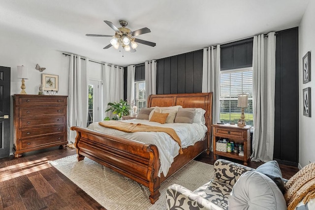 bedroom featuring dark hardwood / wood-style flooring, access to exterior, multiple windows, and ceiling fan