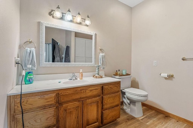 bathroom featuring vanity, hardwood / wood-style floors, and toilet