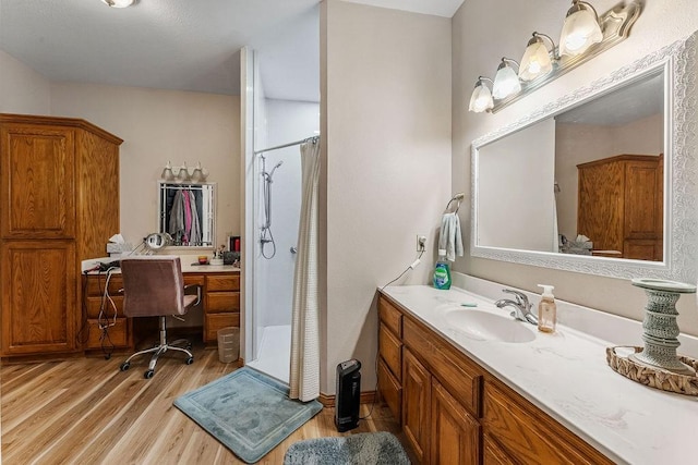 bathroom featuring hardwood / wood-style flooring, vanity, and walk in shower