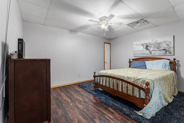 bedroom featuring ceiling fan, a paneled ceiling, and dark hardwood / wood-style flooring