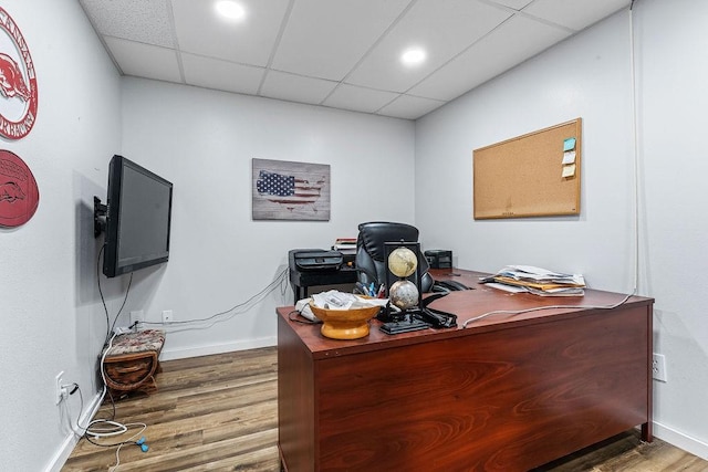 office with wood-type flooring and a drop ceiling