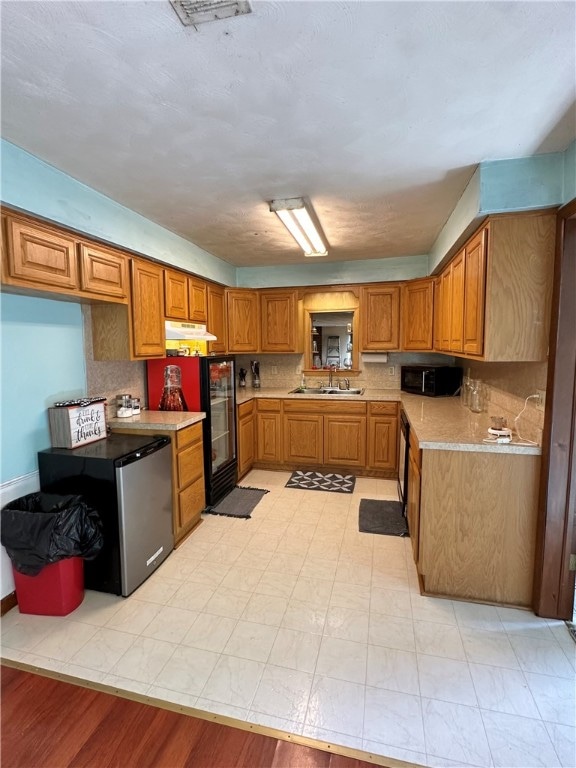 kitchen with sink, decorative backsplash, and light wood-type flooring