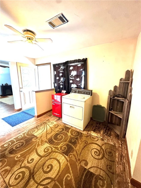 sitting room featuring ceiling fan, washer / dryer, and wood-type flooring