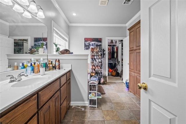 full bathroom with ornamental molding, a walk in closet, visible vents, and vanity