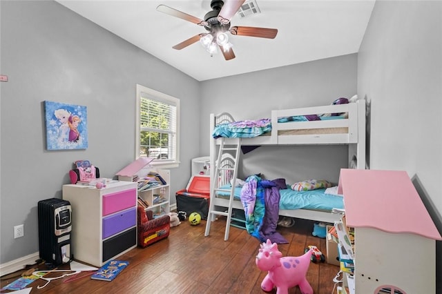 bedroom with baseboards, hardwood / wood-style flooring, visible vents, and a ceiling fan