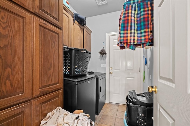 interior space with washing machine and dryer, visible vents, brown cabinets, and light tile patterned flooring