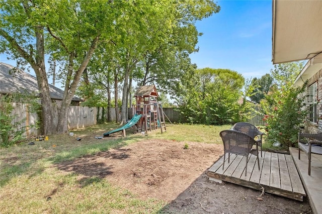 view of yard with a fenced backyard, a playground, and a wooden deck