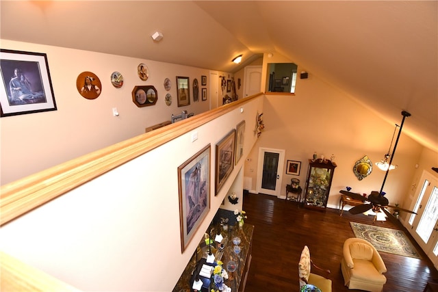 living room with ceiling fan, vaulted ceiling, and dark wood-type flooring