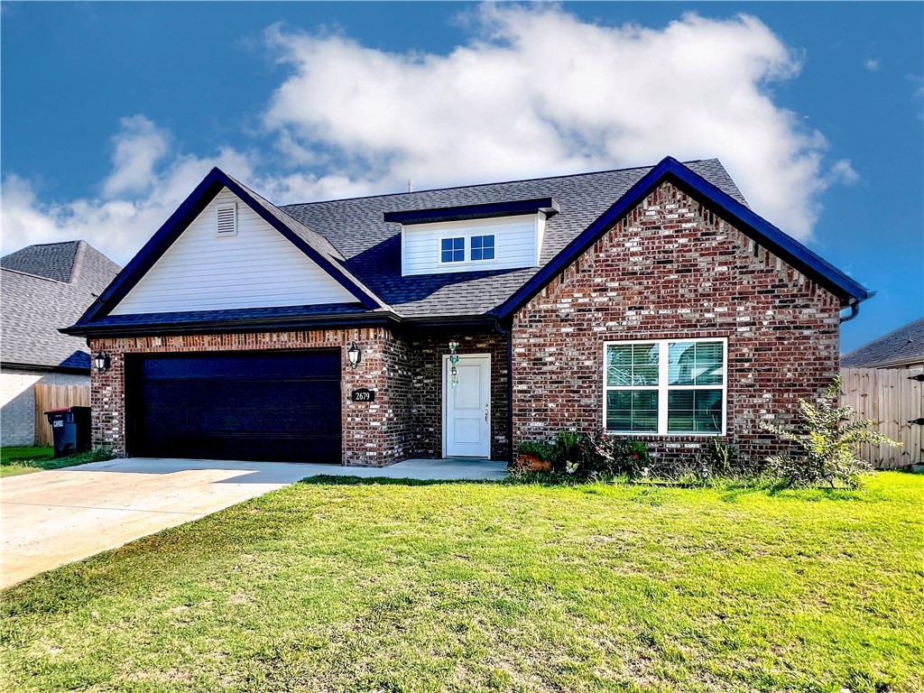 view of front of home with a front yard and a garage