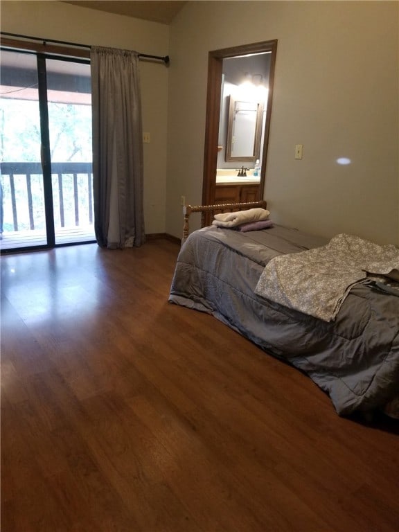 bedroom with access to exterior, ensuite bathroom, and wood finished floors