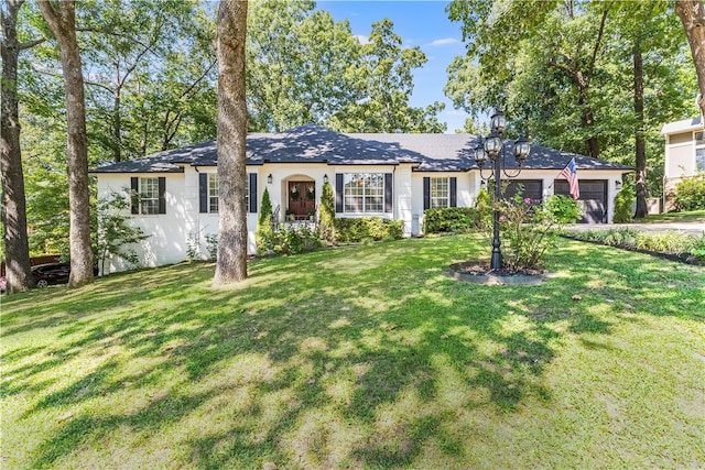 single story home featuring a front yard and a garage