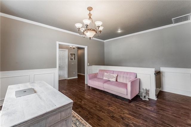 bedroom featuring visible vents, a wainscoted wall, ornamental molding, an inviting chandelier, and wood finished floors