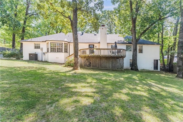 back of house with stucco siding, a deck, a yard, central AC unit, and a chimney