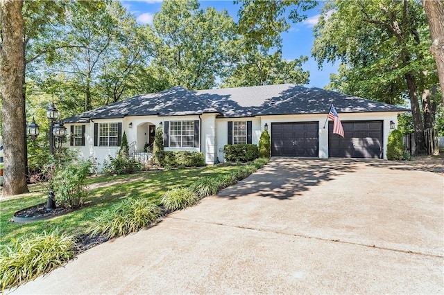 ranch-style house with an attached garage, concrete driveway, and a front yard