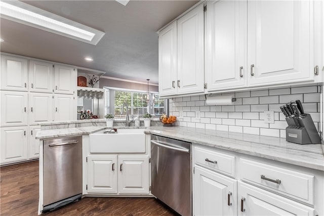 kitchen featuring stainless steel dishwasher, tasteful backsplash, white cabinetry, and a sink