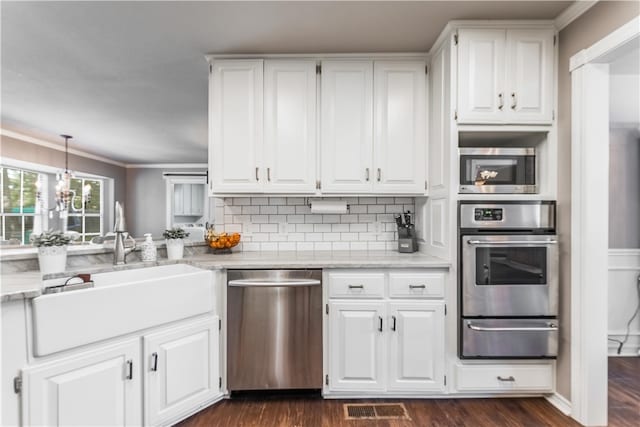 kitchen with visible vents, appliances with stainless steel finishes, white cabinets, a warming drawer, and a sink