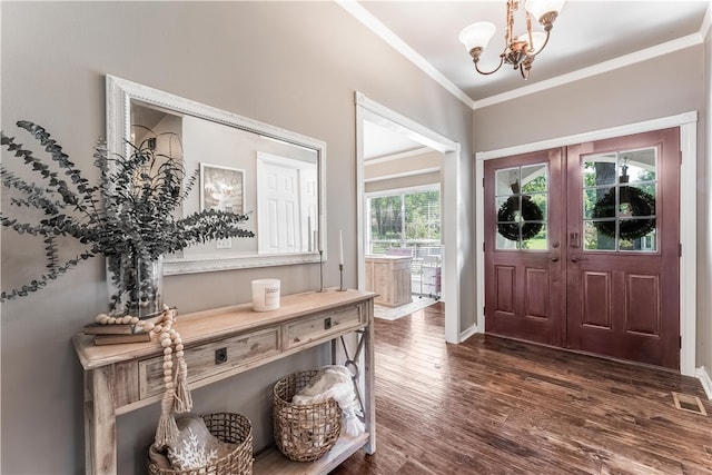 entryway with an inviting chandelier, crown molding, and dark hardwood / wood-style flooring