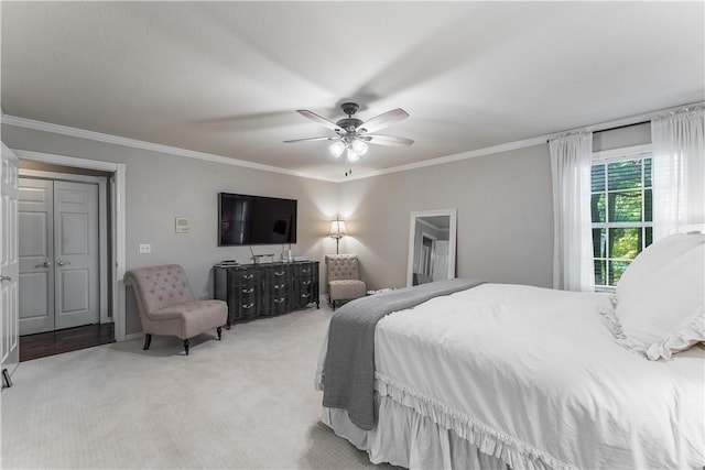 carpeted bedroom featuring ornamental molding and a ceiling fan