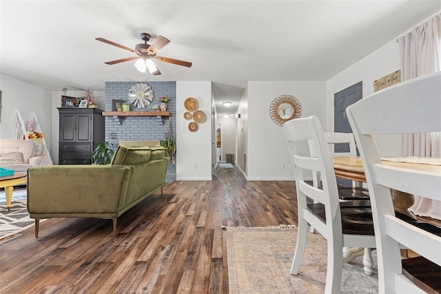 living room featuring a fireplace, brick wall, ceiling fan, and wood-type flooring