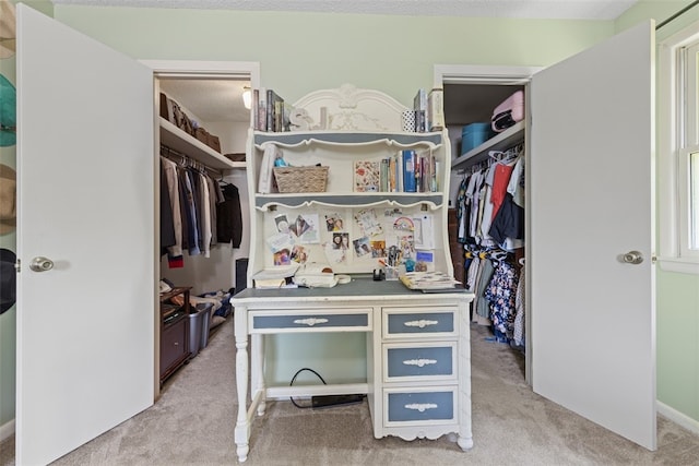 walk in closet featuring light colored carpet